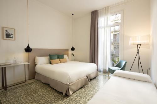 a hotel room with two beds and a window at Forget Me Not Barcelona in Barcelona