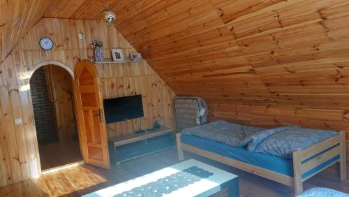 1 dormitorio con 1 cama en una cabaña de madera en Domek z Kominkiem Jaworzynka - Śliwkula, en Jaworzynka