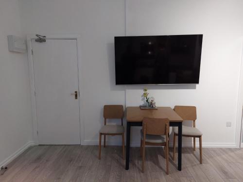 a dining room with a table and chairs and a television at Flat 6 Corner House in Doncaster