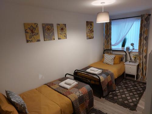 a small room with two beds and a window at Flat 6 Corner House in Doncaster