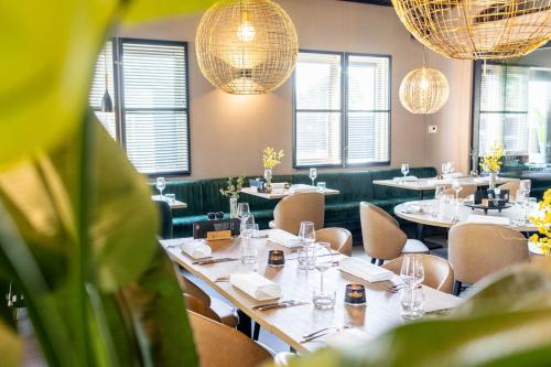 een eetkamer met tafels en stoelen en kroonluchters bij TOP Spa 2+2 in Voorthuizen