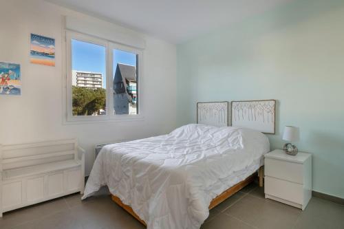 une chambre blanche avec un lit et une fenêtre dans l'établissement Un séjour ou un week-end face mer à la Baule, à La Baule