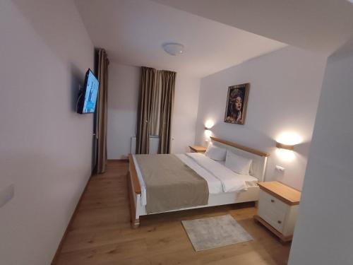 a bedroom with a bed and a tv in it at Casa Ovidiu Rasnov in Râşnov