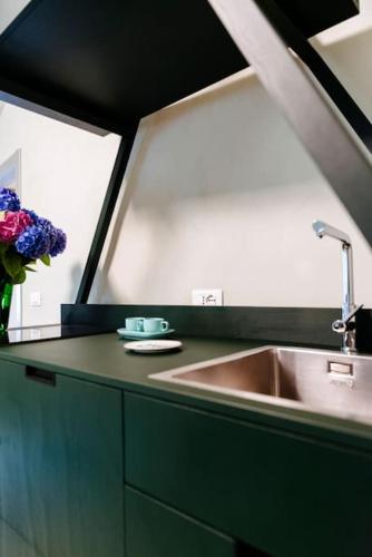 a kitchen with a sink and a vase of flowers at Casa Maer - casa d'artista in Lavenone