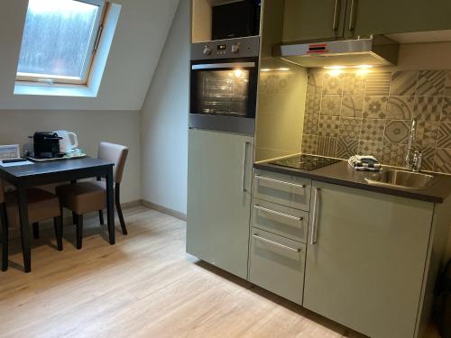 a kitchen with a sink and a table with a table at De Stadspoort appartementen in Aardenburg