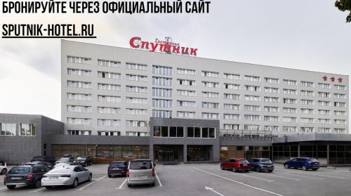 a large building with cars parked in a parking lot at Sputnik Hotel in Saint Petersburg