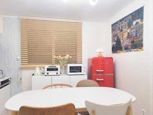 a kitchen with a white table and a red refrigerator at Seoul 리베하우스 3room KSPO-DOM Family trip in Seoul