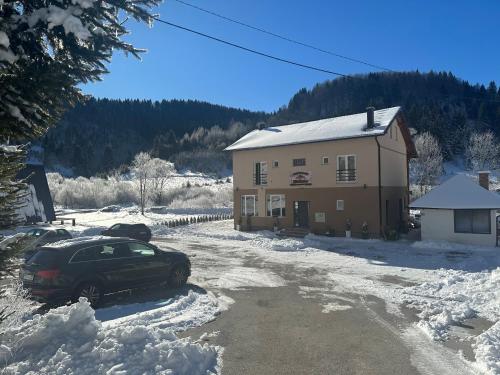 a car parked in the snow in front of a house at Apartman - Sobe Tiha Luka, Bjelašnica in Bjelašnica