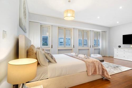 a bedroom with a large white bed with windows at Apartment Boutique Santa Catarina 2 in Porto