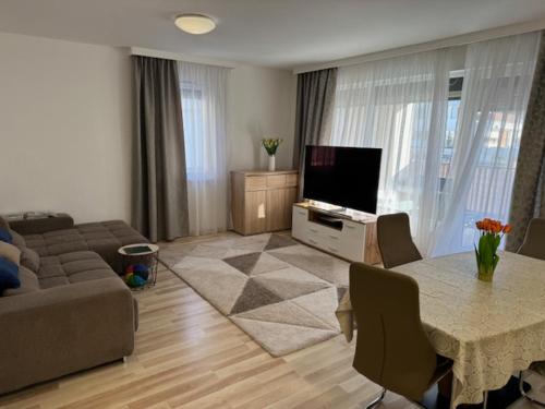 a living room with a couch and a table with a television at Luxury Cordia Apartment with free parking in Budapest