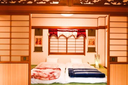 a bedroom with a bed and a window in it at 媛楽園 松山中心地及び道後温泉に近い家族やグループ旅行の多人数が泊まれる快適な宿 in Matsuyama