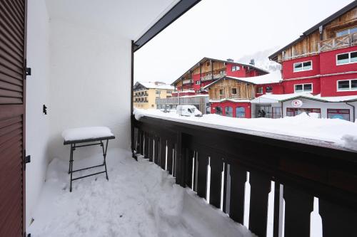 a stool sitting on a balcony in the snow at Alpina Holiday Living Zirbenstrasse in Obertauern