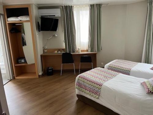 a hotel room with two beds and a desk at Campanile Paris 14 - Maine Montparnasse in Paris