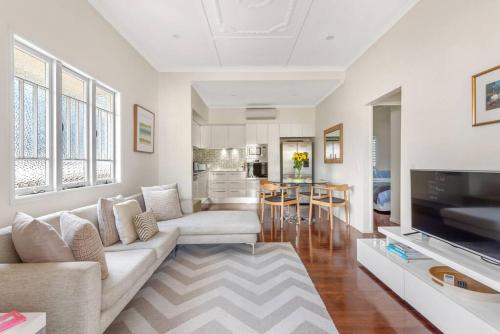 a living room with a couch and a television at Modern Twist + Old World Charm ~ 3Bed/2Bath/2Car in Brisbane