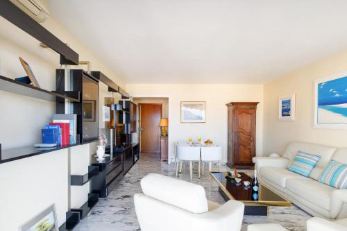 un salon avec des meubles blancs et une table dans l'établissement Gabriel YourHostHelper, à Cannes