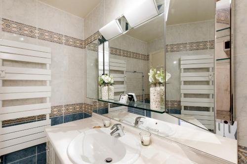 une salle de bain avec un lavabo et un miroir dans l'établissement Gabriel YourHostHelper, à Cannes