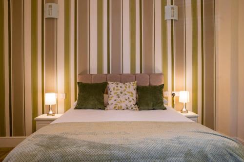 a bedroom with a large bed with two lamps at Cranmere Lichfield in Lichfield
