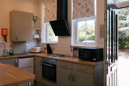uma cozinha com um micro-ondas e um fogão forno superior em Cranmere Lichfield em Lichfield