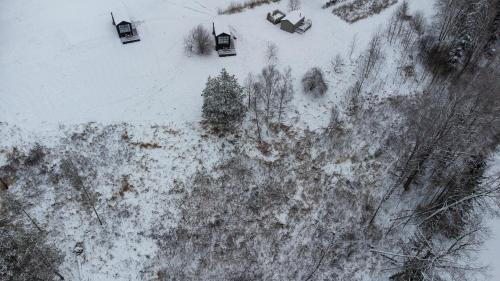 an overhead view of a snow covered hill with trees at Ragnar Glamp Milzkalne Lux in Rauda