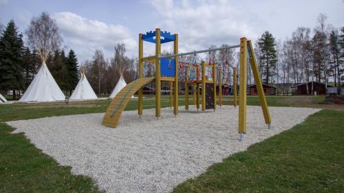 a playground in a park with tents in the background at kemp Pohoda in Roudná