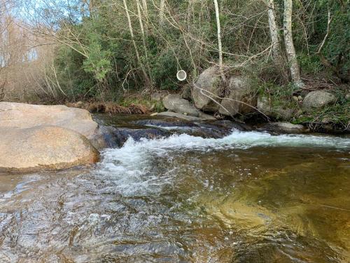 un ruisseau d'eau avec des rochers dans une rivière dans l'établissement Villa l'Albizia accès privé rivière, à Porto-Vecchio