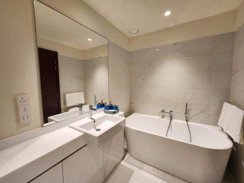 biała łazienka z wanną i umywalką w obiekcie Opulent Comfort w Kolombo