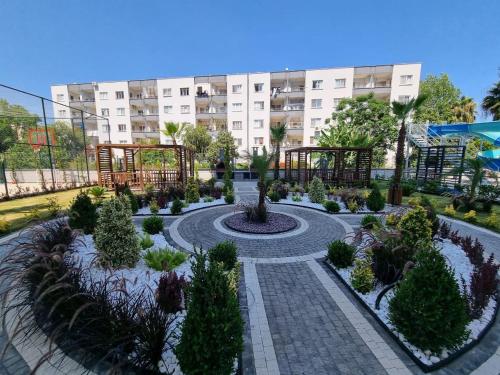 a garden in front of a large building at Uğur Apart Sea View Premium in Mersin