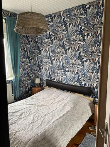 une chambre avec un lit avec un papier peint bleu et blanc dans l'établissement Appt 56m2 en plein centre ville et mer a 200m, à Berck-sur-Mer