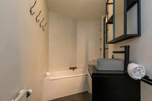 een badkamer met een wastafel en een bad bij Watertoren - Molenwater 2a Middelburg in Middelburg