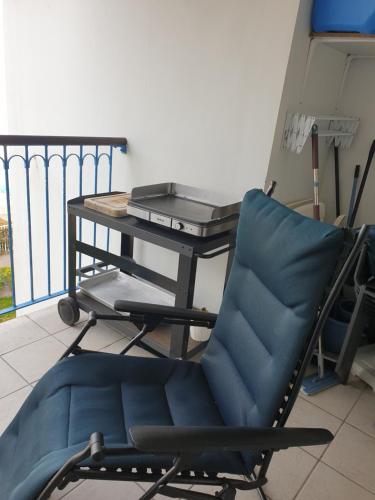 uma cadeira ao lado de uma mesa na varanda em Appartement face Mer em Tréboul