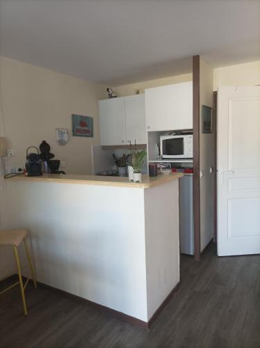 - une cuisine avec un comptoir blanc et un four micro-ondes dans l'établissement Appartement vue Mer, à Tréboul