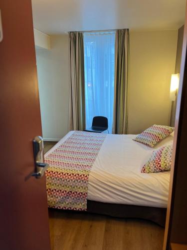 a hotel room with a bed and a window at Campanile Paris 14 - Maine Montparnasse in Paris