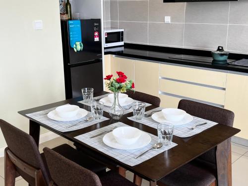 a kitchen with a table with plates and flowers on it at D'pristine by Antlerzone in Johor Bahru