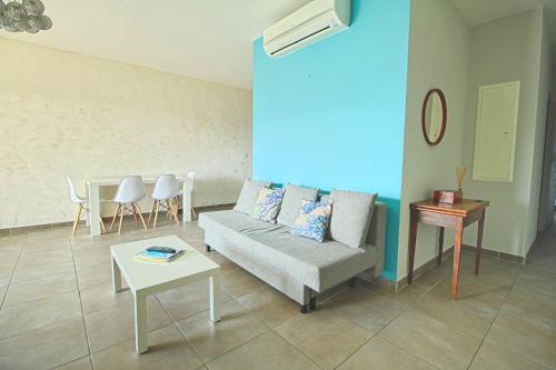 un salon avec un canapé et une table dans l'établissement Appartement Roi Théodore Ajaccio, à Ajaccio