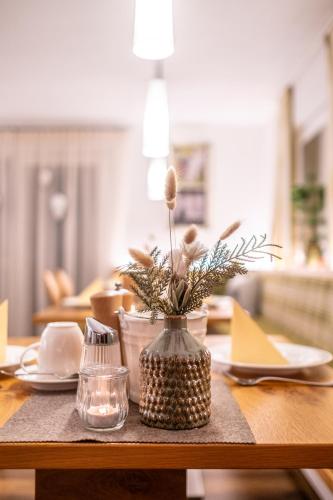 a table with a vase with a flower in it at HOFERHOF Schladming -Dachstein in Schladming