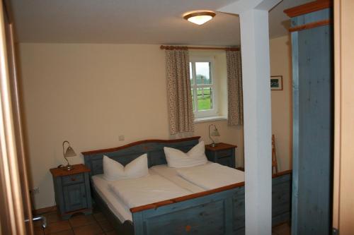 um quarto com uma cama com lençóis brancos e uma janela em Landhaus am Esch em Warendorf