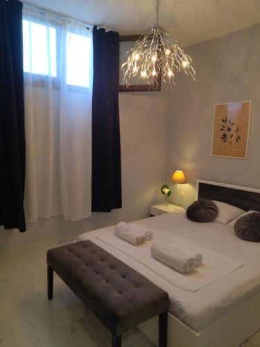 a bedroom with a large bed and a chandelier at STONEHOUSE & CASA AL SOLE e AL MARE in Nea Roda