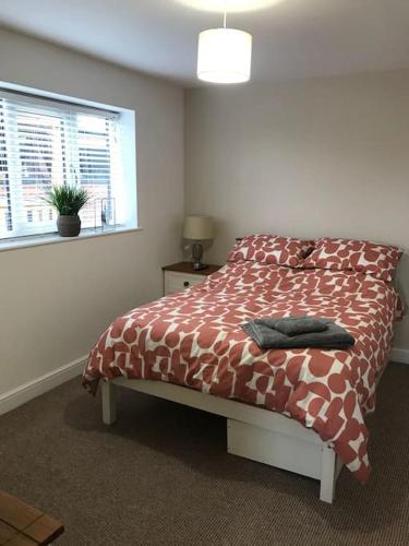 a bedroom with a bed with a comforter and a window at Springwood farm in Kirkhamgate