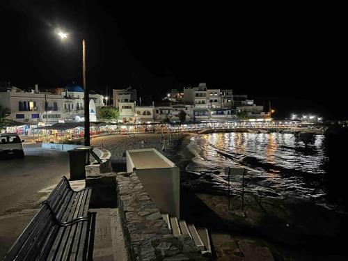 a street light and a bench next to the water at night at Cozy Studio in Beautiful Apollonas Beach Naxos in Apollon