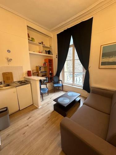 un salon avec un canapé et une table dans l'établissement Charmant appartement de 38m² -Quartier Latin, à Paris