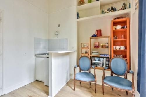 twee stoelen en een tafel in een kamer bij Charmant appartement de 38m² -Quartier Latin in Parijs