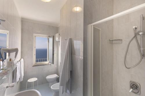 y baño con ducha, aseo y lavamanos. en Hotel Villa Lubrense Sorrento, en Massa Lubrense