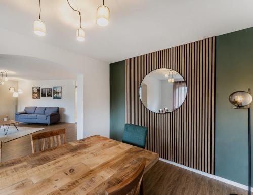 a dining room with a wooden table and a mirror at WohlfühlDomizil am Solemar in Bad Dürrheim