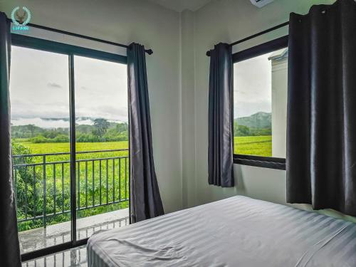 a bedroom with a bed and a window with a view at Espano 1 in Ban Tha Chang