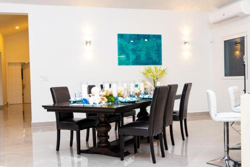 a dining room with a black table and chairs at Lovely 4-Bed Villa in Anguilla in Long Path