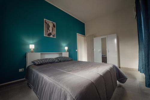 1 dormitorio con 1 cama con pared verde en Casa Vacanze - Il Balconcino sul Castello, en Iglesias