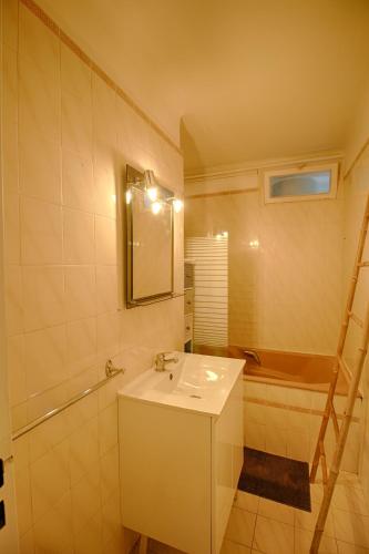 une salle de bain avec un lavabo, une baignoire et un miroir dans l'établissement Appartement Eugénie centre-ville Ajaccio, à Ajaccio