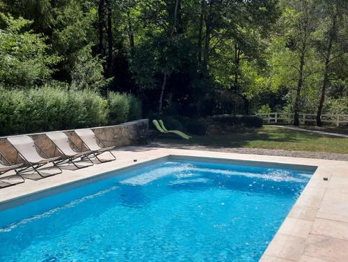 a swimming pool with two lounge chairs next to it at Le Moulin du Paroy in Serres