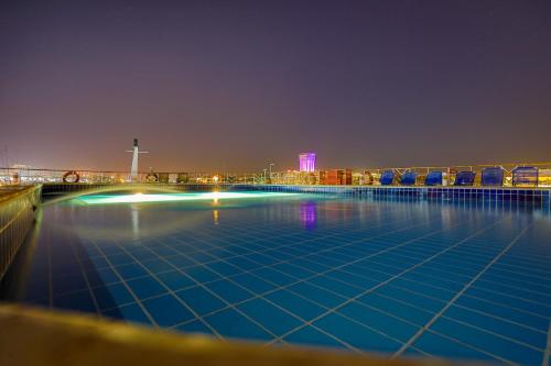 a swimming pool at night with a city in the background at M/S Nephtis Nile Cruise in Luxor