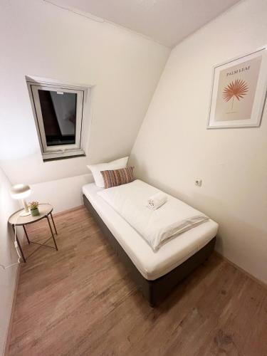 ein kleines Schlafzimmer mit einem Bett und einem kleinen Tisch in der Unterkunft Lilly's Häuschen in Obereisenheim